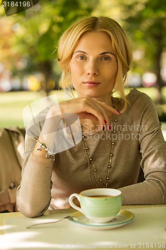 Image of portrait of a beautiful young woman in park.