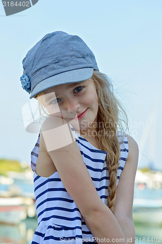 Image of Portrait of little girl in denim cap outdoors