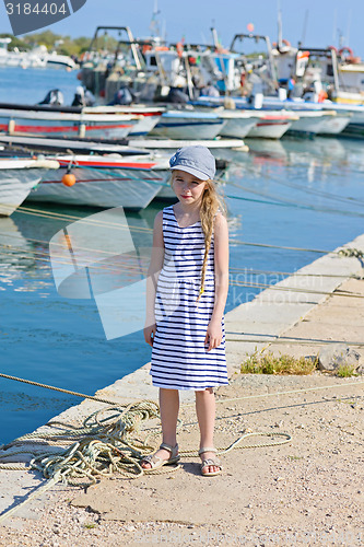 Image of Little girl in the harbor in striped dress