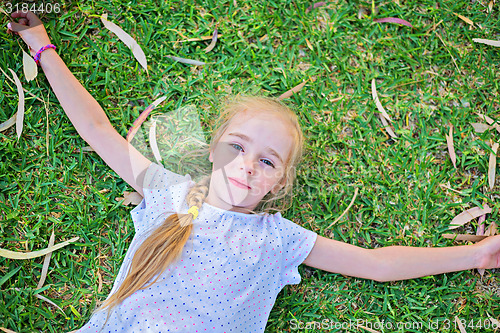 Image of Caucasian small girl lay on grass