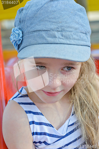 Image of Portrait of small girl in striped clothes outdoors