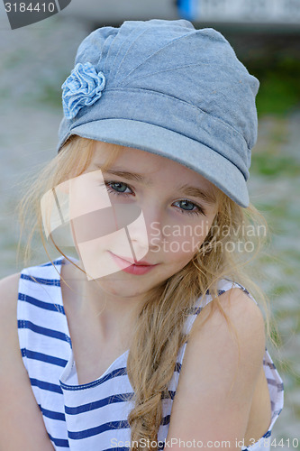 Image of Portrait of small girl in denim cap outdoors