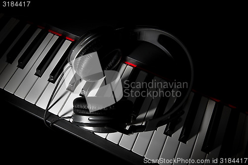 Image of Piano keyboard with headphones