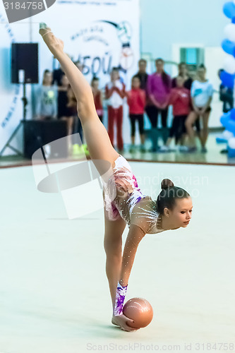 Image of Young attractive girl shows exercise with ball