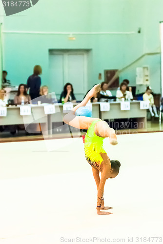 Image of Young girl shows exercise with ball to judges