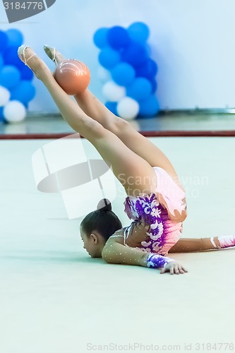 Image of Young attractive girl shows exercise with ball