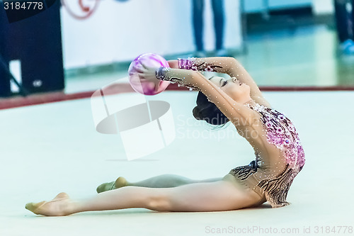 Image of Young attractive girl shows exercise with ball