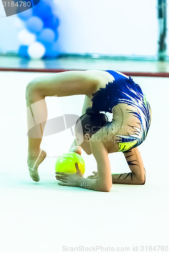 Image of Young pretty girl shows exercise with ball