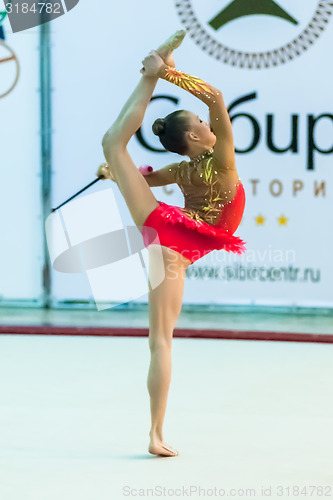 Image of Young attractive girl shows exercise with maces