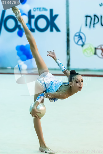 Image of Young attractive girl shows exercise with ball
