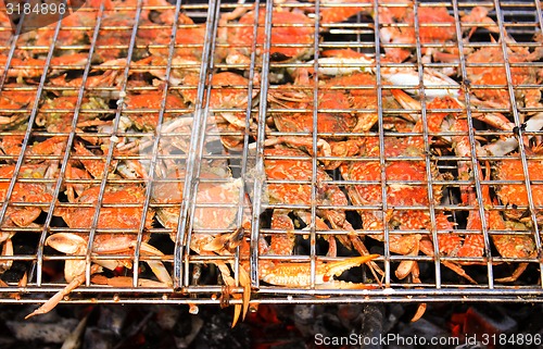 Image of Grilled crab on flaming grill.