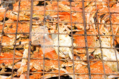 Image of Grilled crab on flaming grill. 