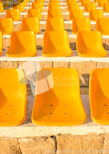 Image of Stadium Yellow Chairs at sun light.