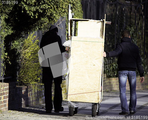 Image of Men moving things on street