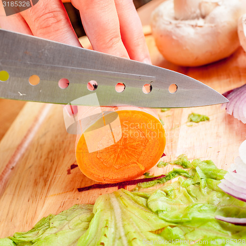 Image of Woman\'s hands cutting vegetables