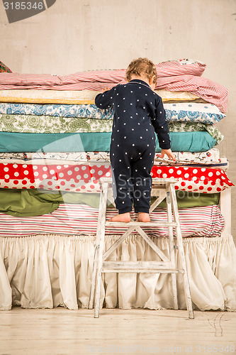 Image of Child climbs on the bed - Princess and the Pea.
