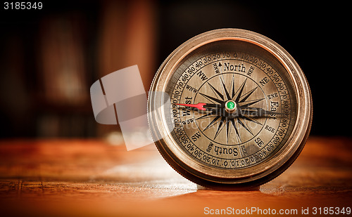 Image of Vintage compass lies on an ancient world map.