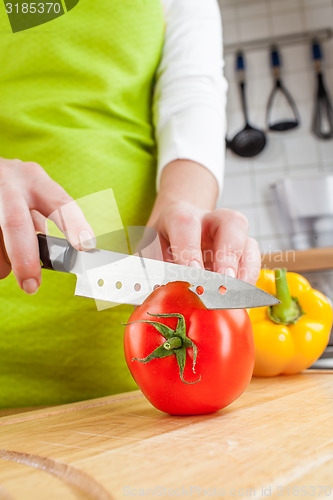 Image of Woman\'s hands cutting tomato