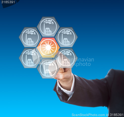 Image of Business Hand Activating Solar Power Icon On Blue