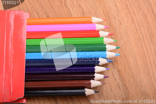 Image of colored pencils on wooden background