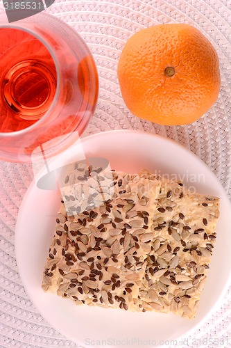 Image of sweet cake on white plate, red wine and fruits