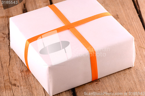 Image of white gift box on wooden plate