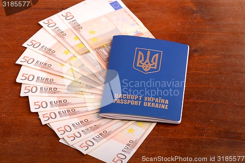 Image of ukrainian passport and one hundred euro banknotes