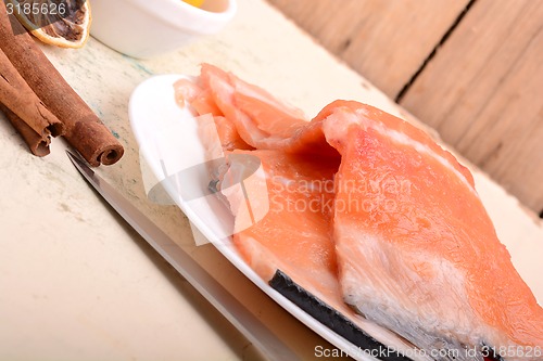 Image of Fresh uncooked red fish fillet slices and cinnamon