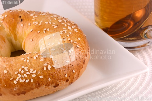 Image of cup of tea and some cookies on white material background