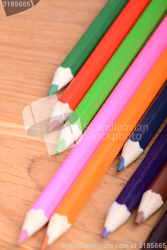 Image of colored pencils  on wooden background