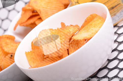 Image of Glass of light beer and potato chips on a wooden table