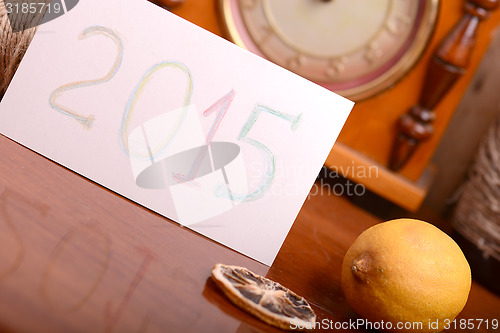 Image of old lemon and clock on wooden plate