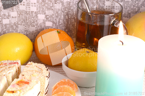 Image of sweet cake on white plate with fruits and candle