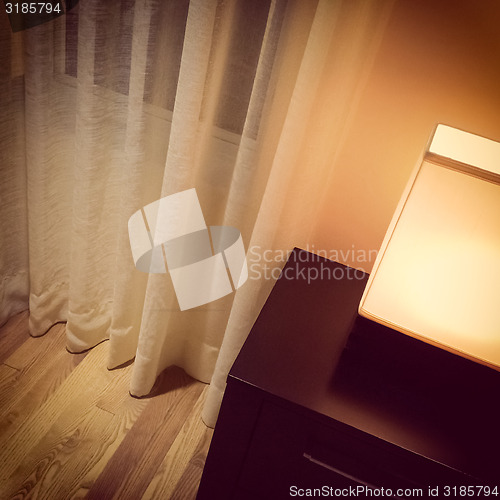 Image of Cozy lamp in a room with white curtains