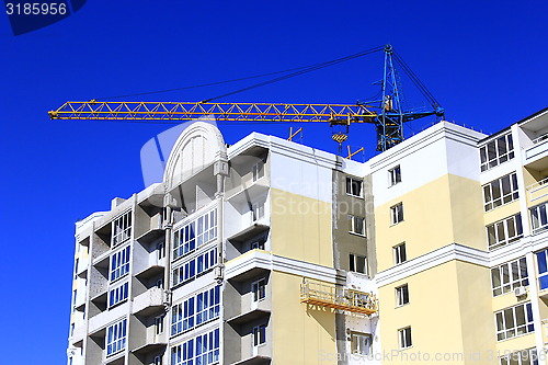 Image of construction of multistorey modern house with hoisting crane