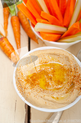 Image of fresh hummus dip with raw carrot and celery 