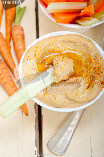 Image of fresh hummus dip with raw carrot and celery 