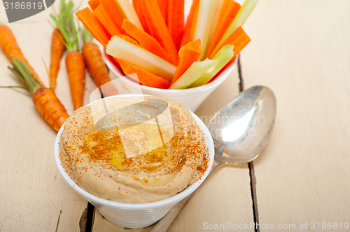 Image of fresh hummus dip with raw carrot and celery 