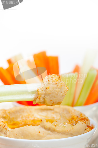 Image of fresh hummus dip with raw carrot and celery 