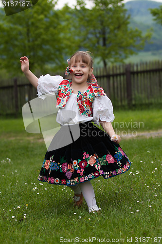 Image of Little girl in traditional costume with flowers