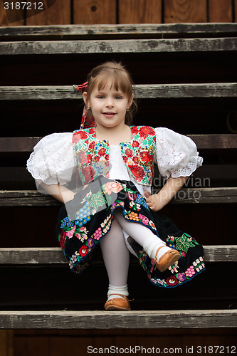 Image of Sitting little girl in traditional costume