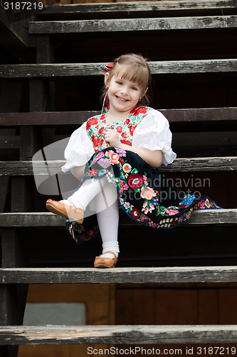 Image of Sitting little girl in traditional costume