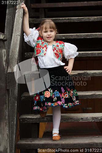 Image of Little girl in traditional costume on the stairs