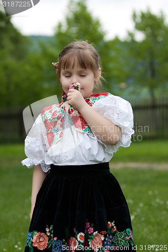 Image of Little girl in traditional costume with flowers