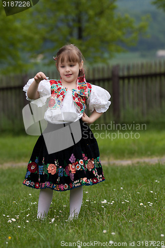 Image of Small girl in traditional dress on the meadow