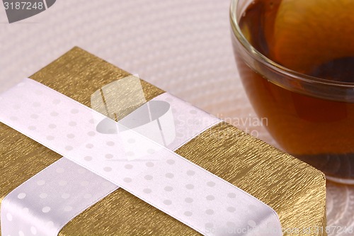 Image of glass cup of tea and gift box