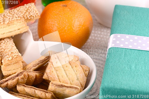 Image of sweet cake on white plate, gift box, fruits and juice