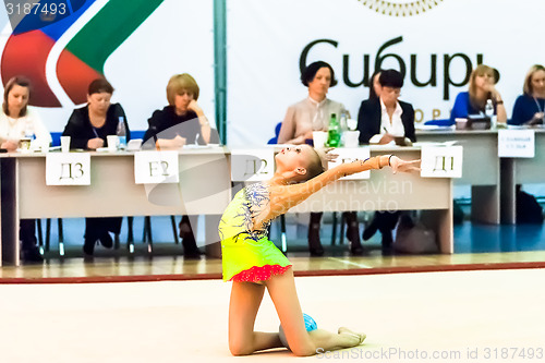 Image of Young girl shows exercise with ball to judges