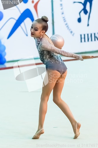 Image of Young beautiful girl shows exercise with ball