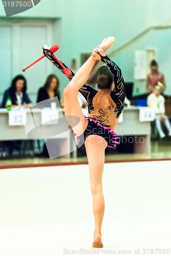 Image of Young beautiful girl shows exercise with maces